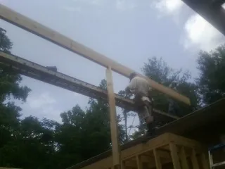 Carpenter setting a ridge beam over a new addition frame — Ice Dam Removal by Roofing Brothers in Hickory