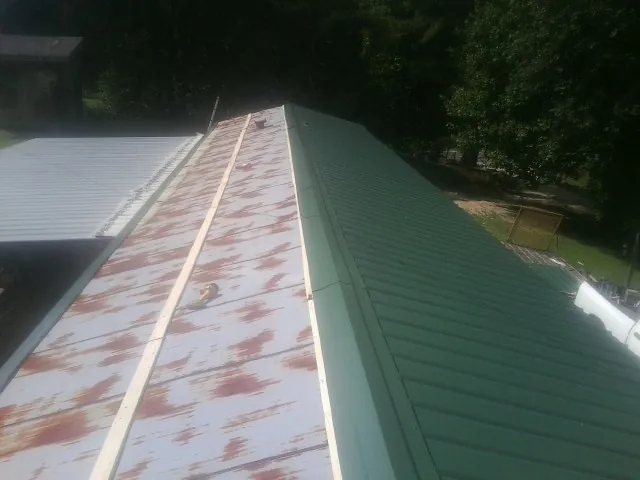 Old rusted panels beside newly installed green metal roofing — Wind Damage Roof Repair by Roofing Brothers in Hickory