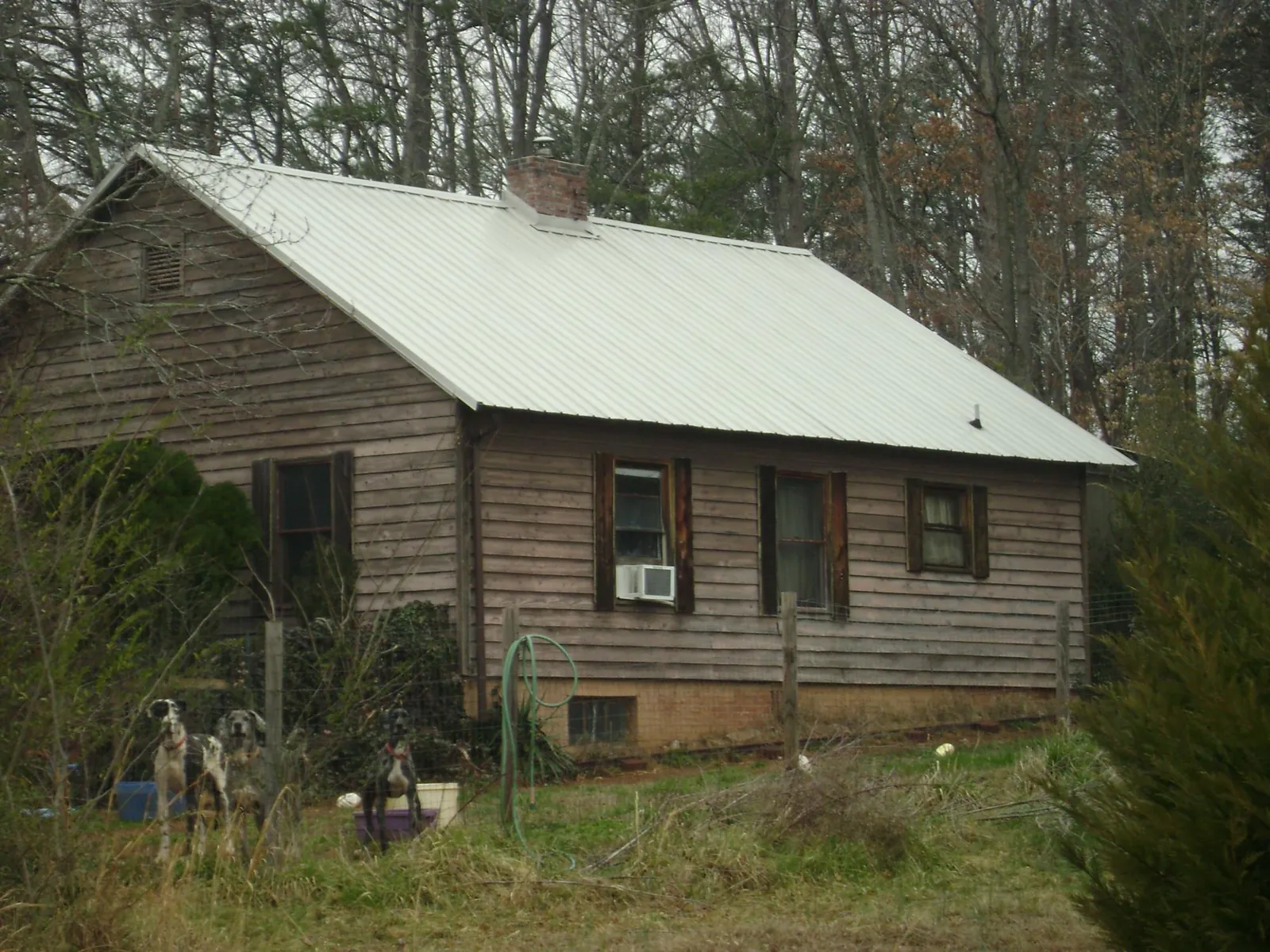 White metal roof on an old wood sided farmhouse, from a Metal Roof Installation job in Hickory